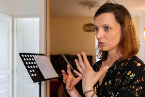 En cours de chant Femme qui parle à côté d'un pupitre.